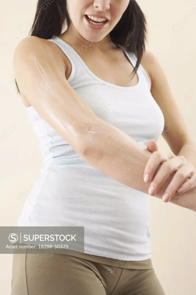 Woman Rubbing Lotion on Arm   