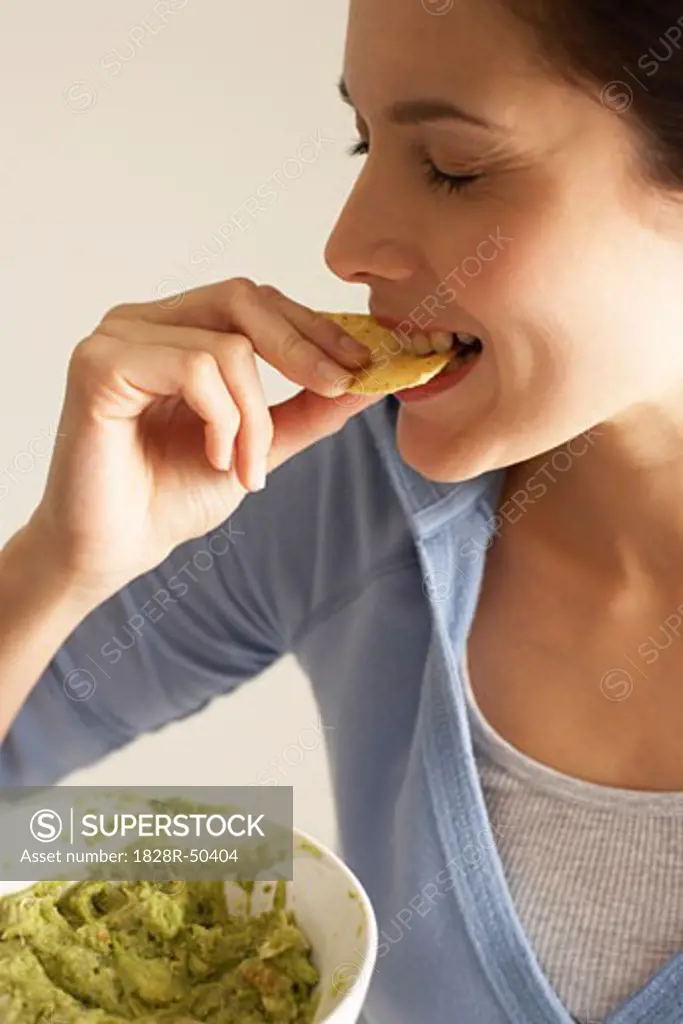 Woman Eating Chips and Dip   