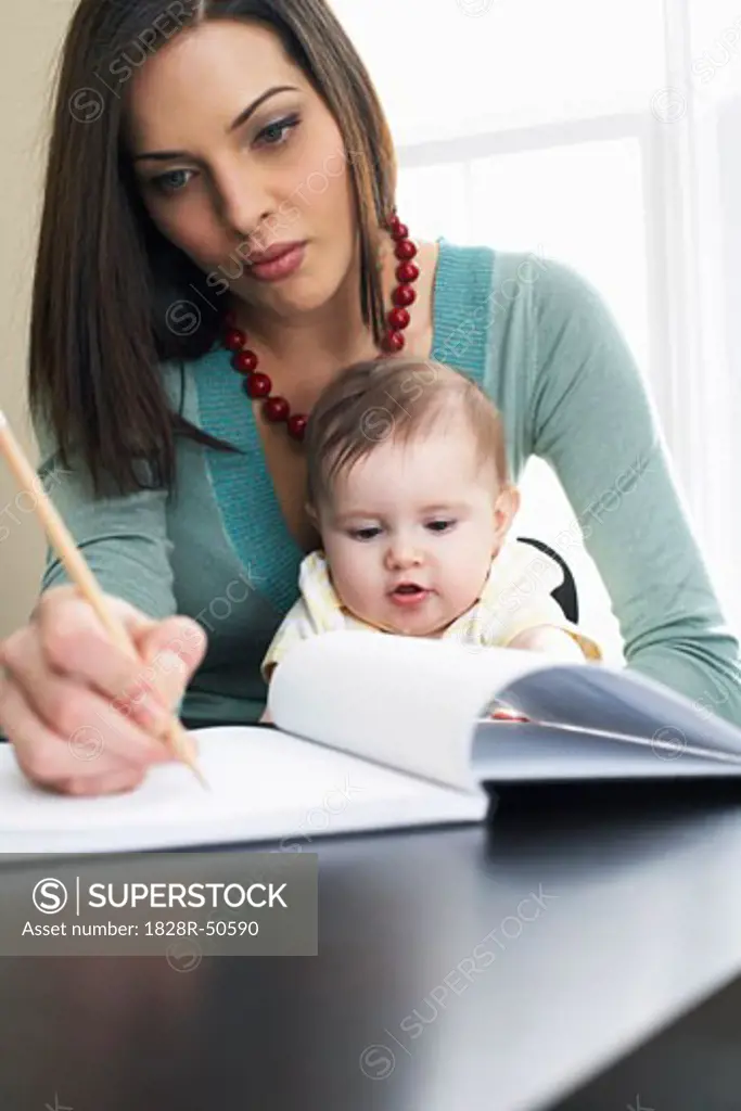 Mother Writing in Notebook, With Baby on Her Lap   