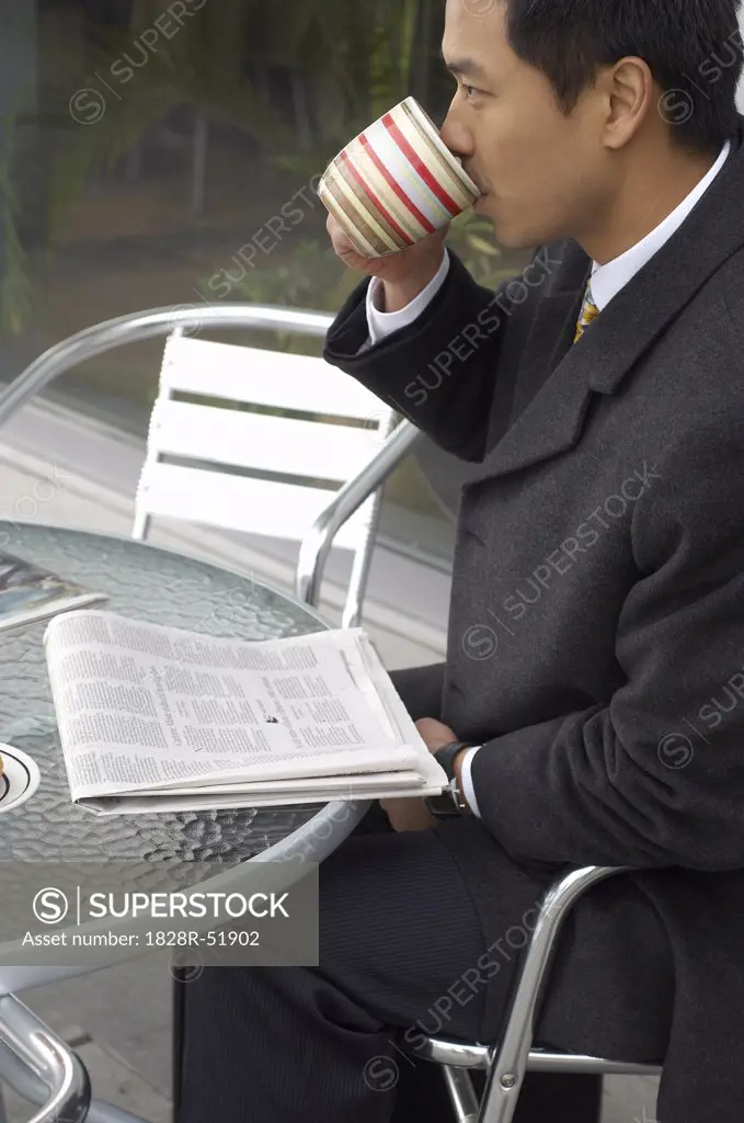 Man Drinking Coffee At Cafe Table   