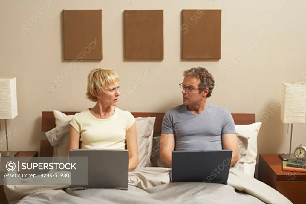 Couple Working in Bed   