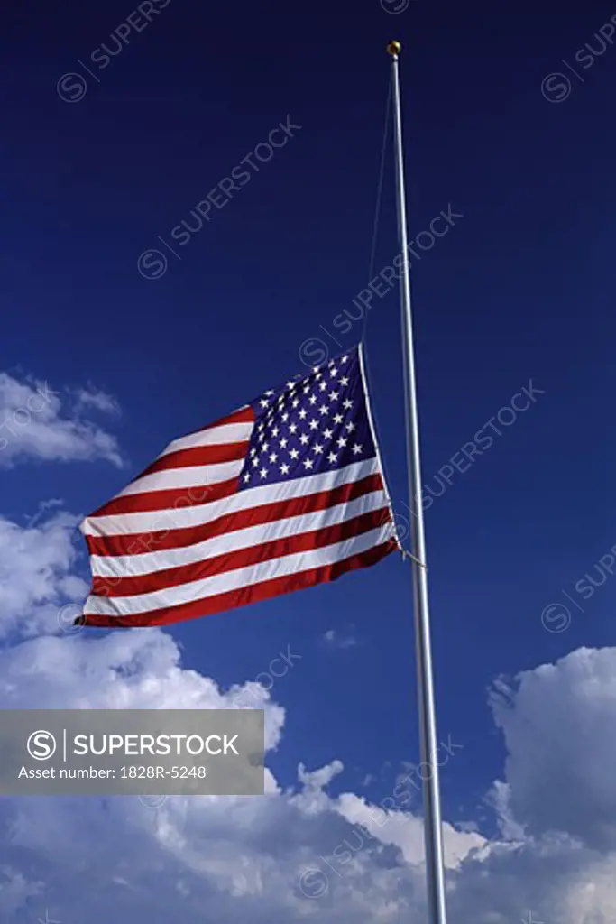 American Flag at Half Mast with Clouds in Sky   