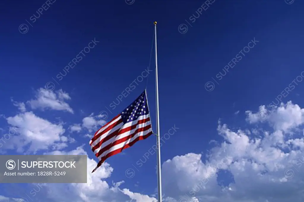 American Flag at Half Mast with Clouds in Sky   