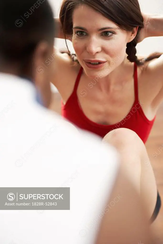 Woman Doing Sit-ups with Trainer   