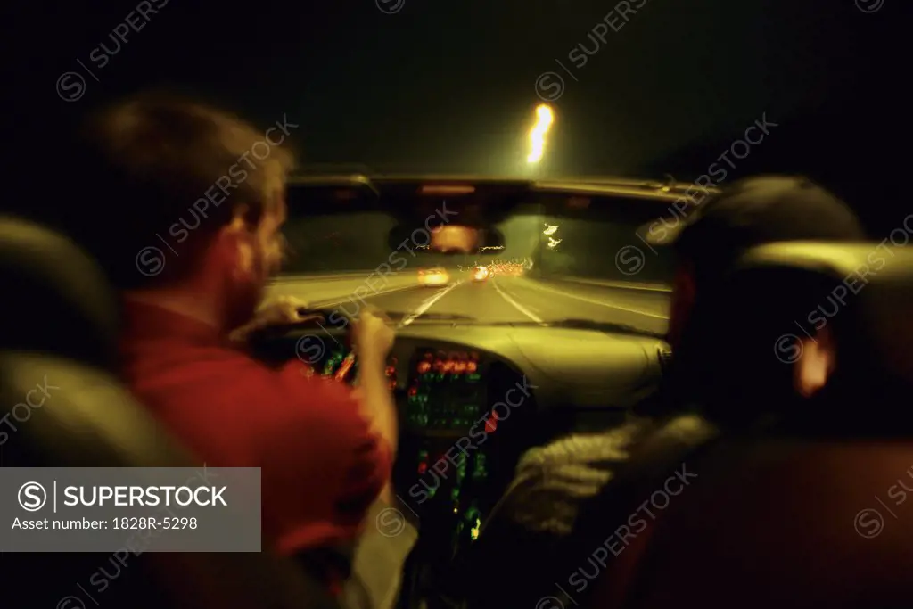Two Men Driving in Car at Night, Toronto, Ontario, Canada   