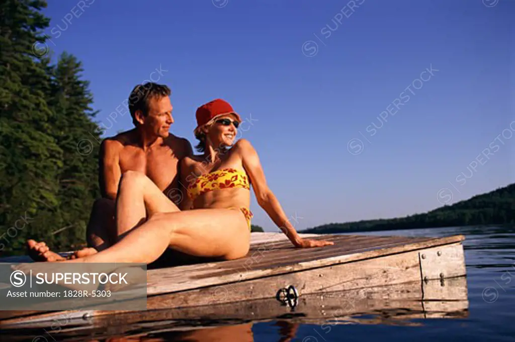 Couple in Swimwear, Relaxing on Dock, Belgrade Lakes, Maine, USA   