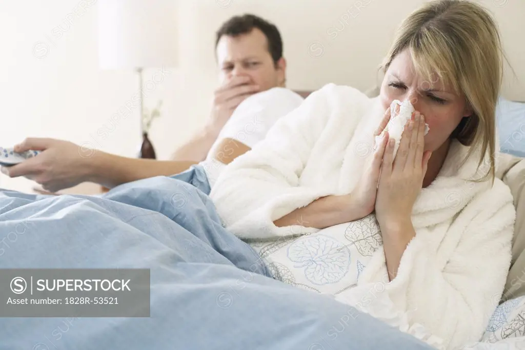 Woman Blowing Nose in Bed   