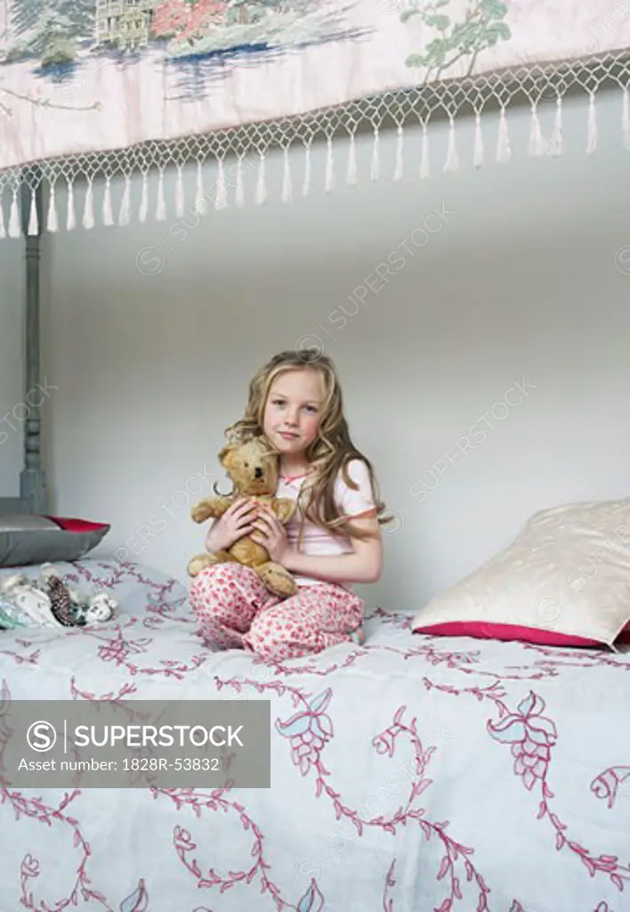 Girl Sitting on Bed, Holding Teddy Bear   