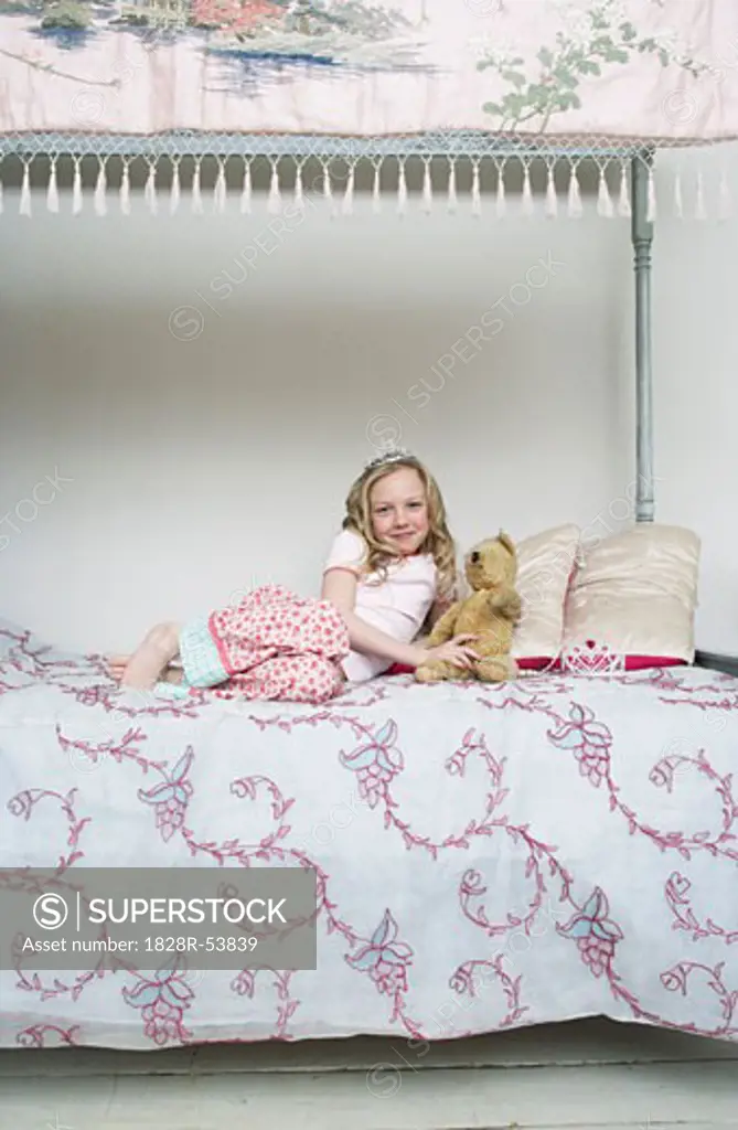 Girl Sitting on Bed, Holding Teddy Bear and Wearing Tiara   