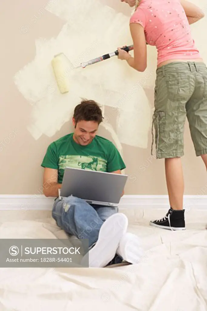 Man on Laptop While Woman Paints   