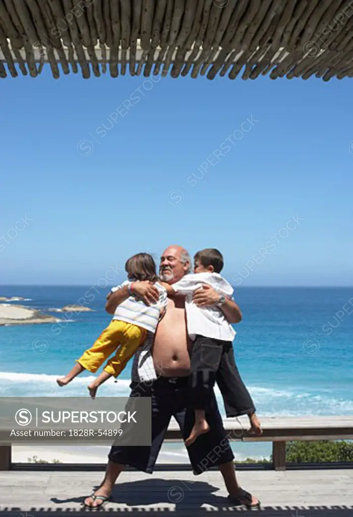 Grandfather Playing With Grandsons at the Beach   