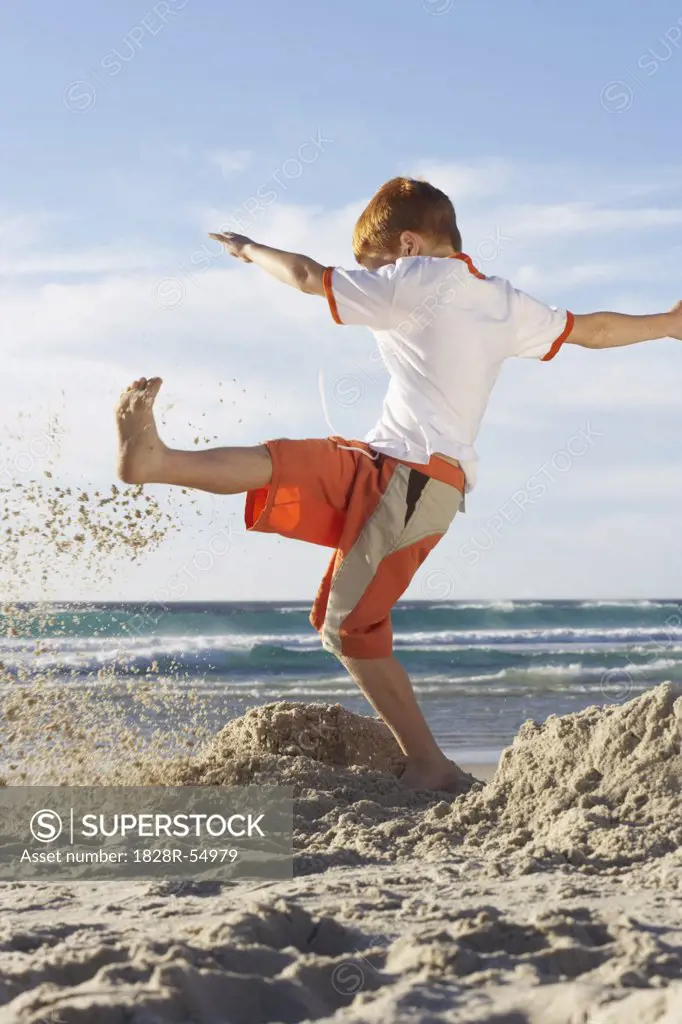 Boy Kicking Sandcastles   