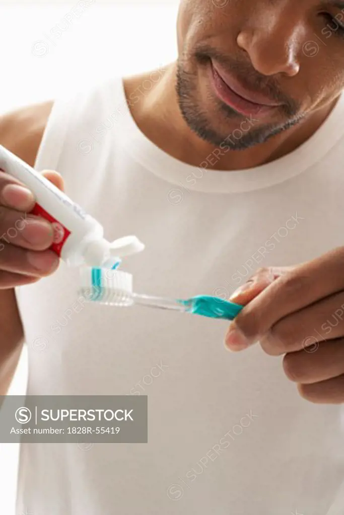 Man Putting Toothpaste on Toothbrush   
