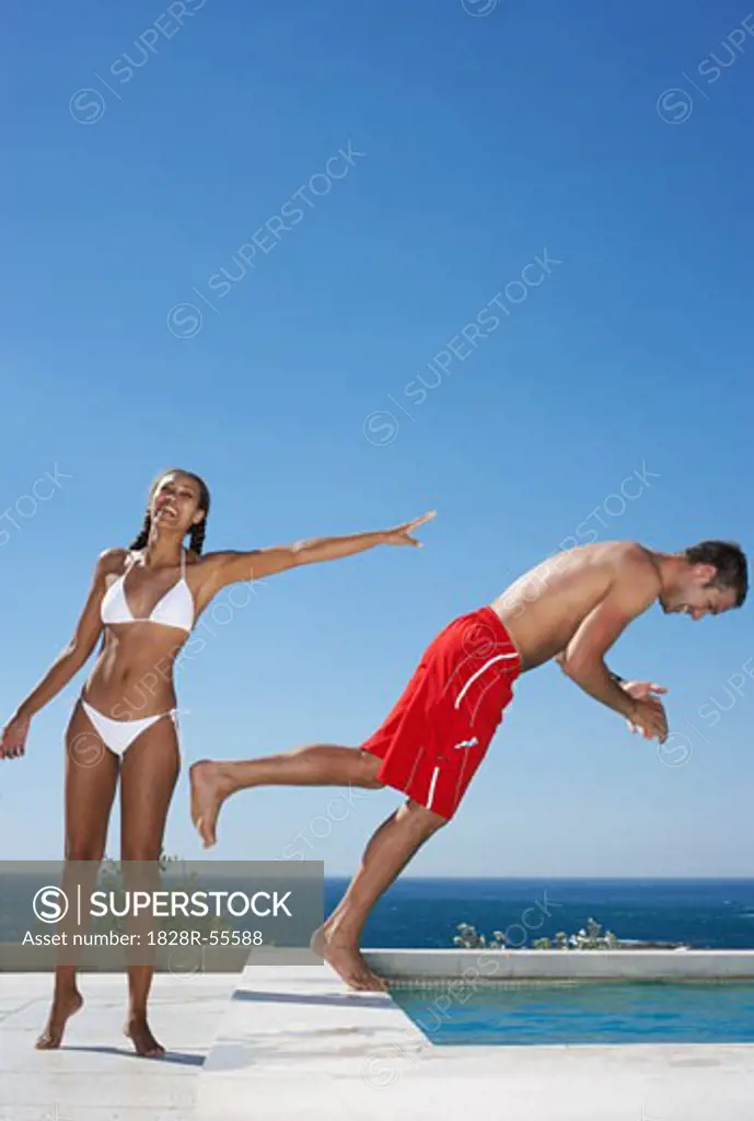 Woman Pushing Man Into Swimming Pool   