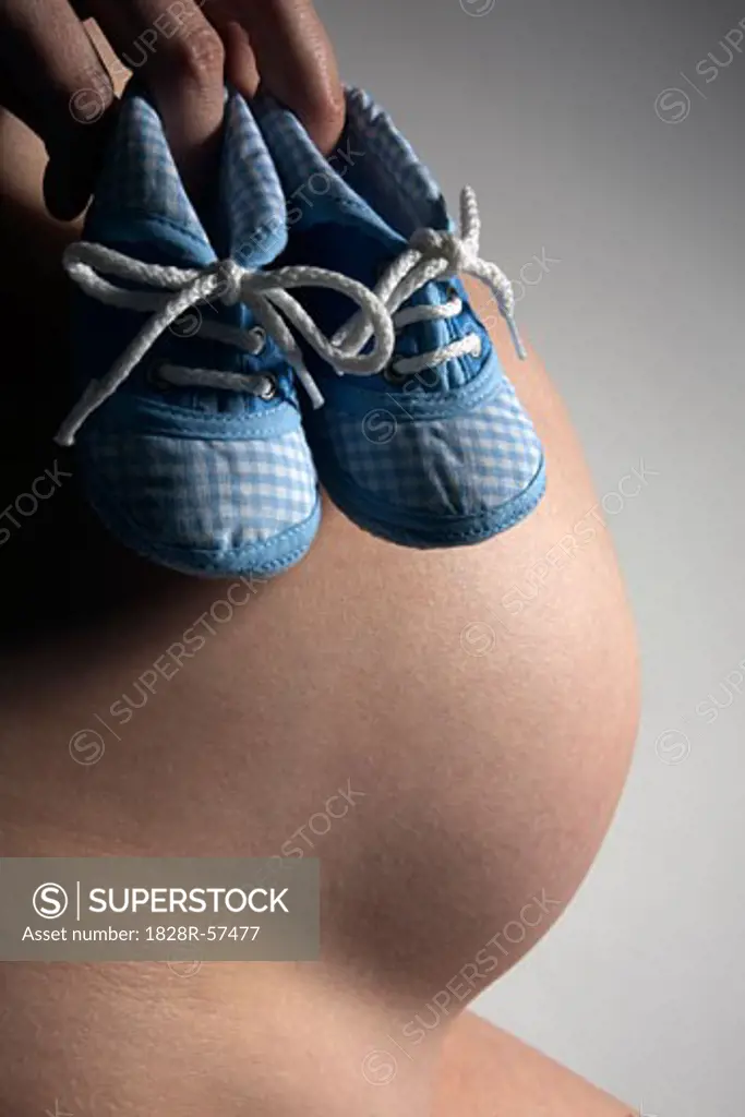 Woman Holding Baby's Shoes