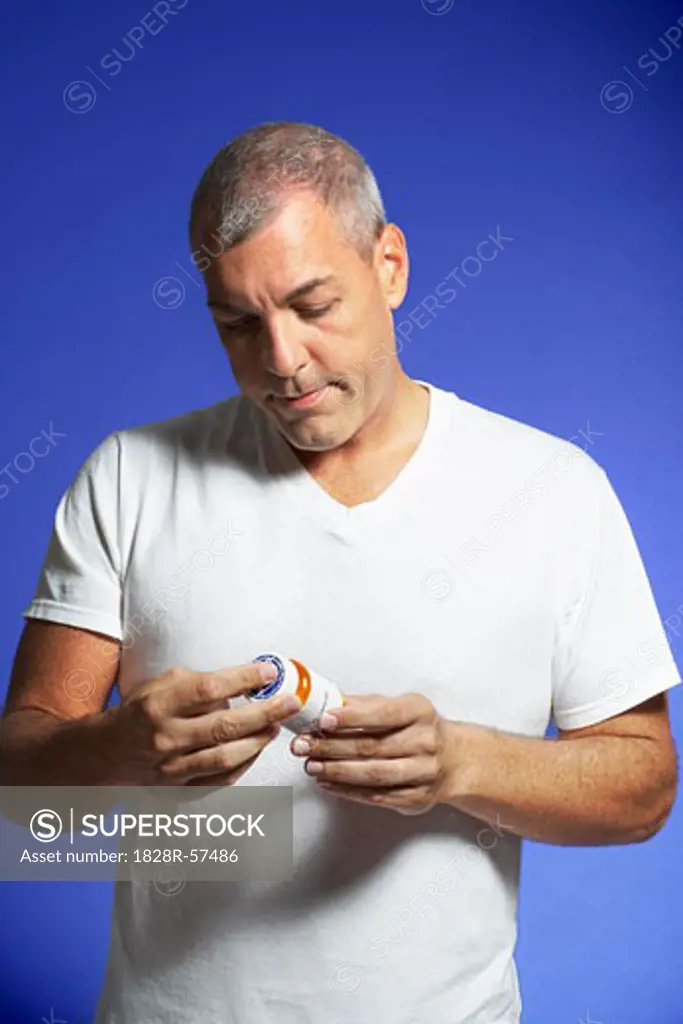 Man Looking at Pill Container   