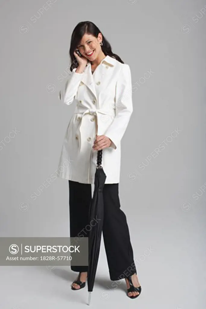 Portrait of Businesswoman Holding Umbrella and Talking on Cell Phone   