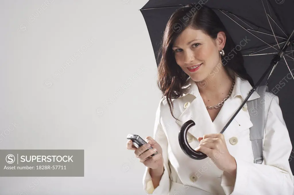 Portrait of Businesswoman Holding Umbrella and Sending Text Message   