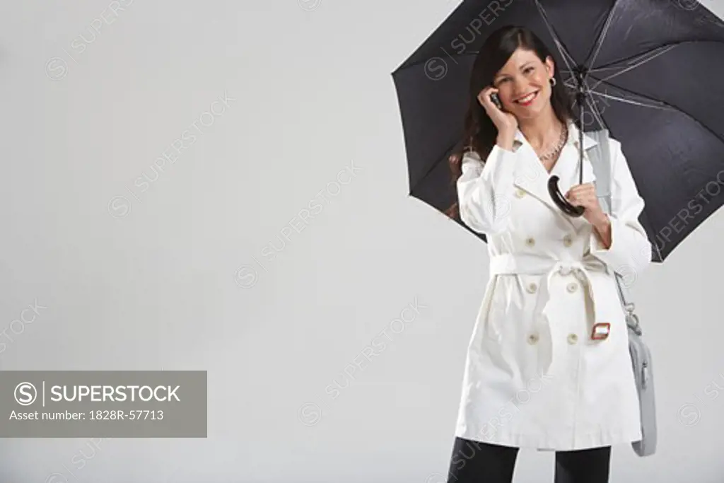 Portrait of Businesswoman Holding Umbrella and Talking on Cell Phone   