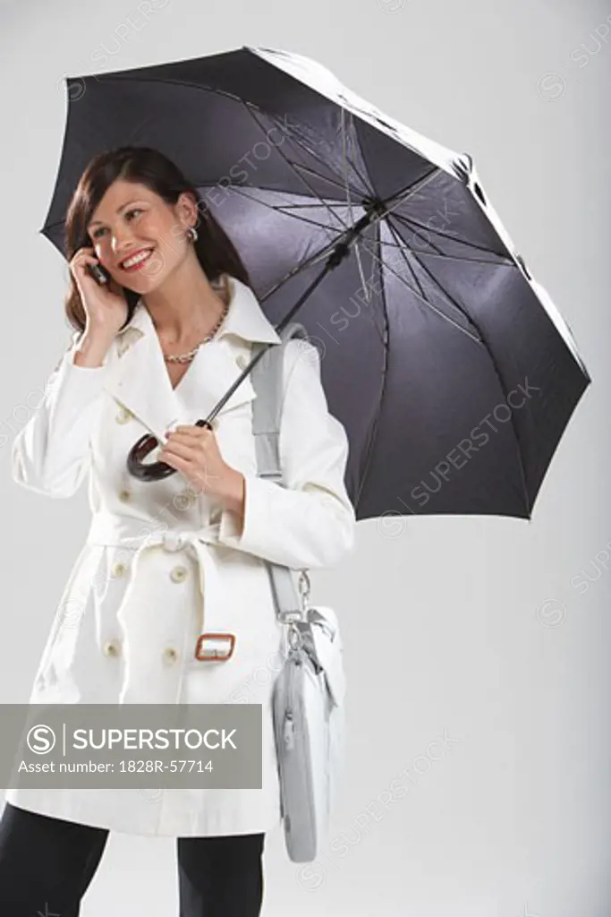 Businesswoman Holding Umbrella and Talking on Cell Phone   