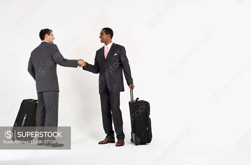 Businessmen With Luggage Shaking Hands   