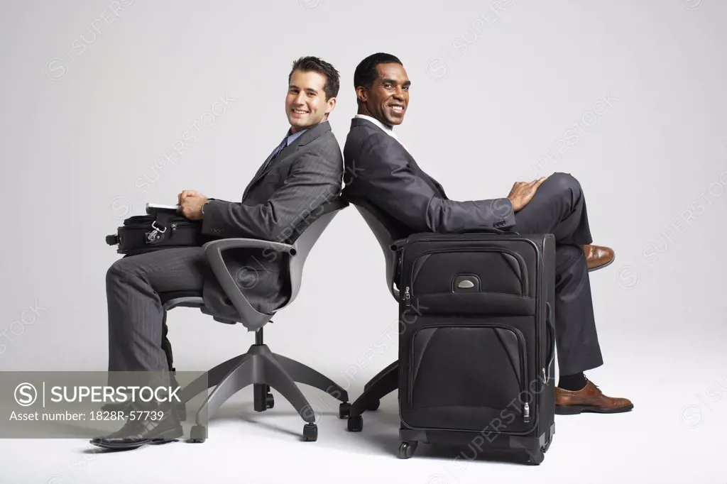 Businessmen Sitting Back to Back in Office Chairs   