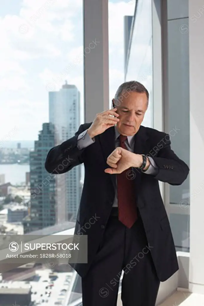 Businessman Talking on Cell Phone, Looking at Watch   
