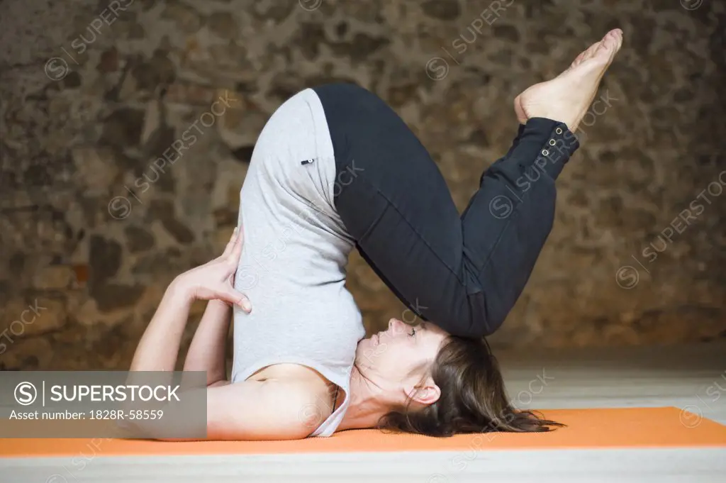 Woman in Yoga Class Doing Shoulder Stand   