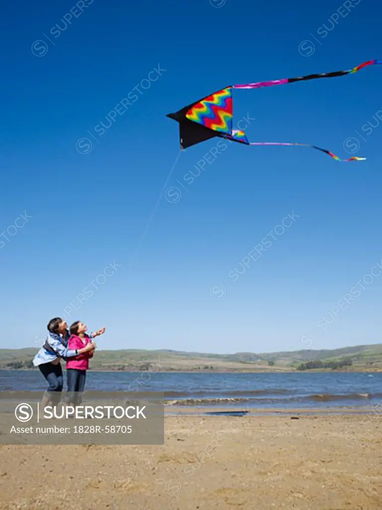 Mother and Daughter Flying Kite on Beach   