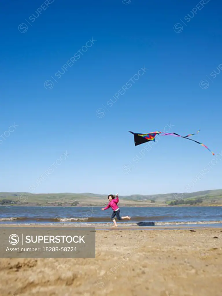 Girl Flying Kite on Beach   