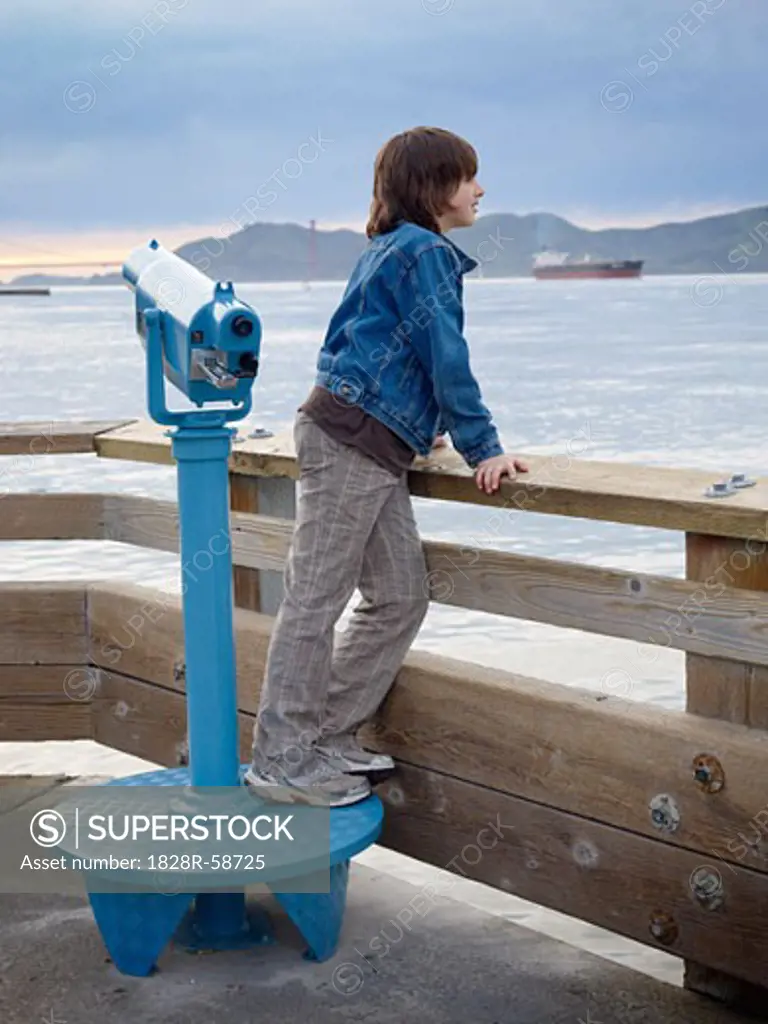 Boy Looking over Water from Pier, San Francisco, California, USA   
