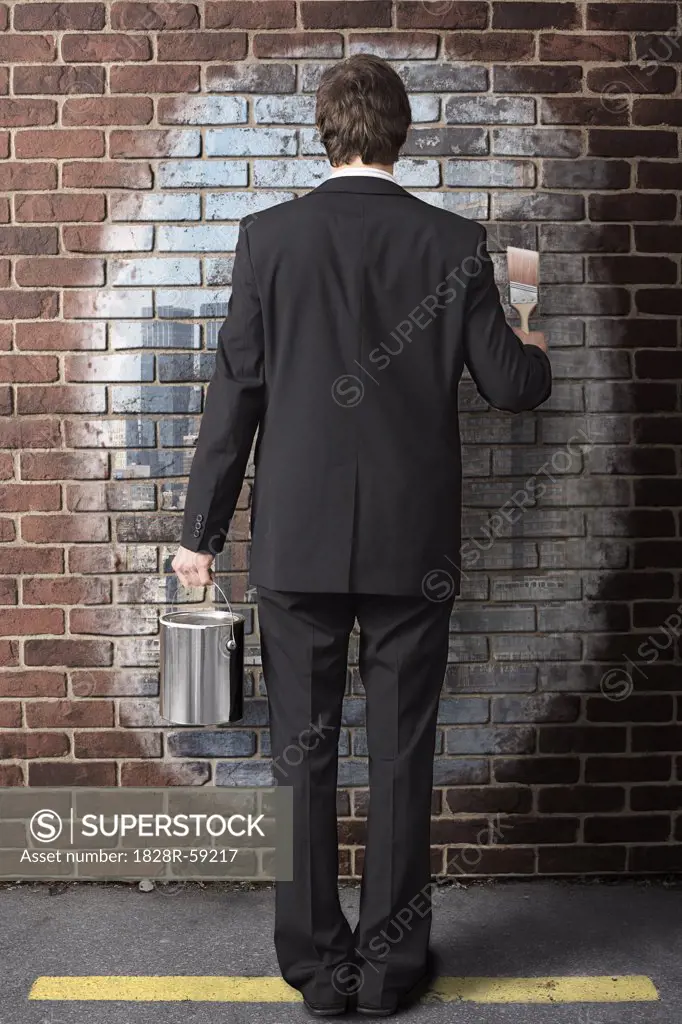 Businessman Painting on Brick Wall   