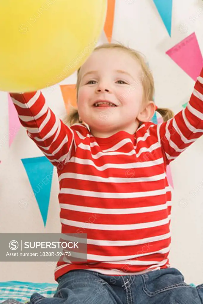 Little Girl Playing With a Balloon at a Birthday Party   