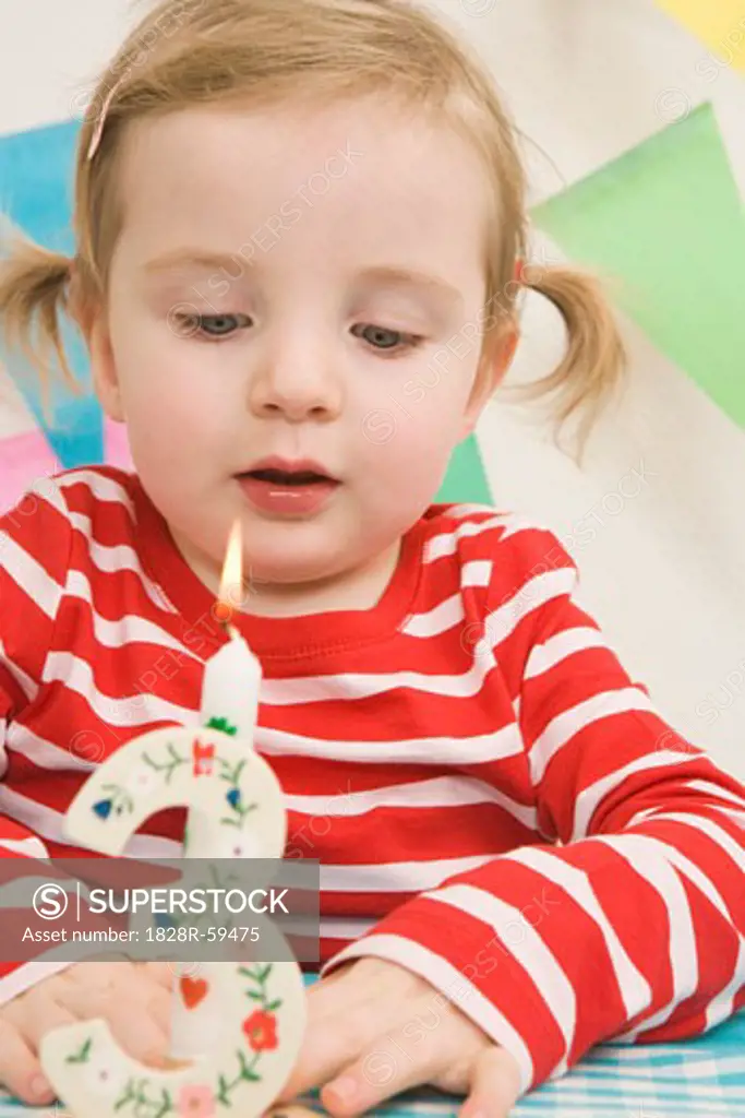 Little Girl Blowing Out Candle at a Birthday Party   