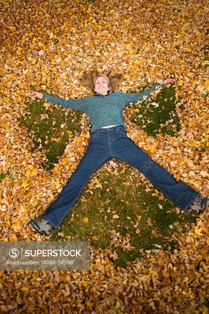 Woman Playing in Leaves in Autumn, Bend, Oregon, USA