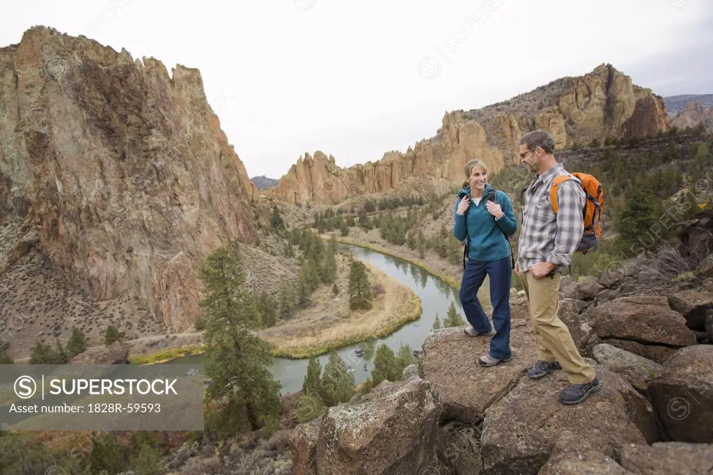 Hikers Standing on a Cliff Above Crooked River in Smith Rock State Park in Autumn, Bend, Oregon, USA   