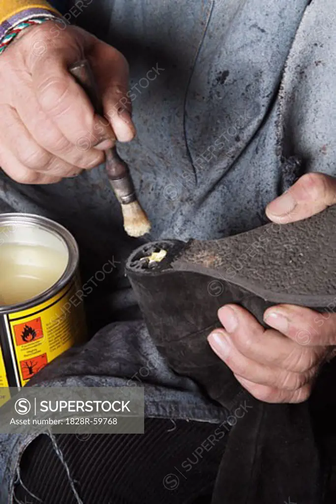 Close-up of Italian Shoemaker Applying Glue to Heel of Boot   