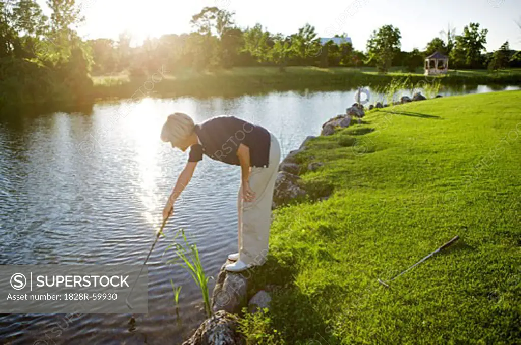 Woman Looking for Golf Ball in Water, Burlington, Ontario, Canada   