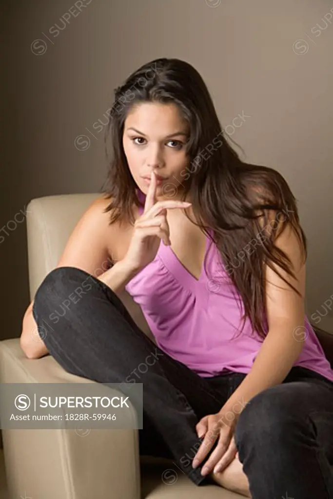 Woman Sitting in Chair Making Hand Gesture   