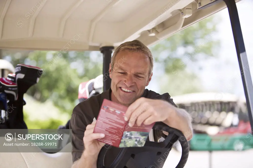 Man with Score Card in Golf Cart   