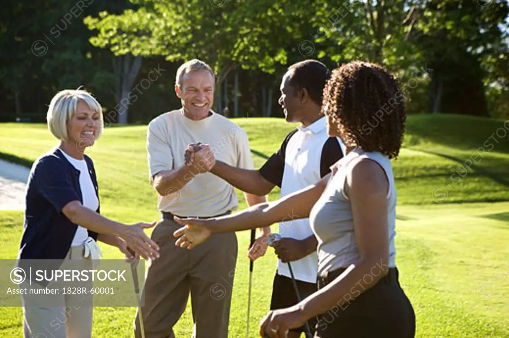 Couples Shaking Hands on Golf Course   