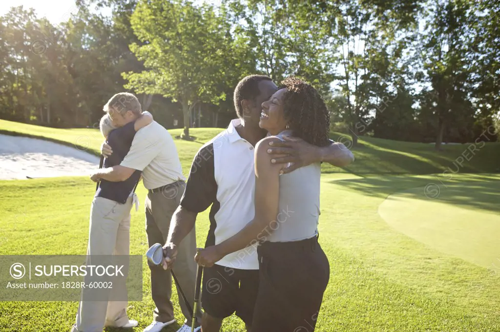 Couples Hugging on Golf Course   