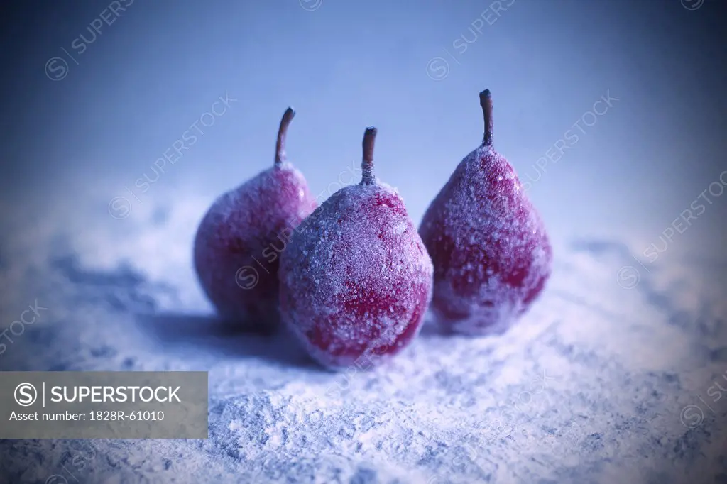 Three Red Candied Pears on Snowy Background   