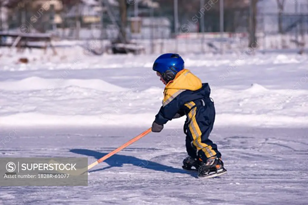 Little Boy Playing Hockey on a Frozen Pond, Fuschlsee, Salzburger Land, Austria   