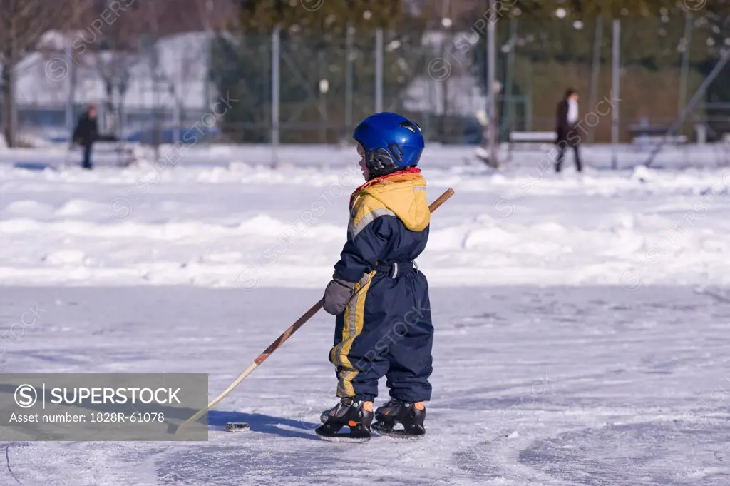 Little Boy Playing Hockey on a Frozen Pond, Fuschlsee, Salzburger Land, Austria   