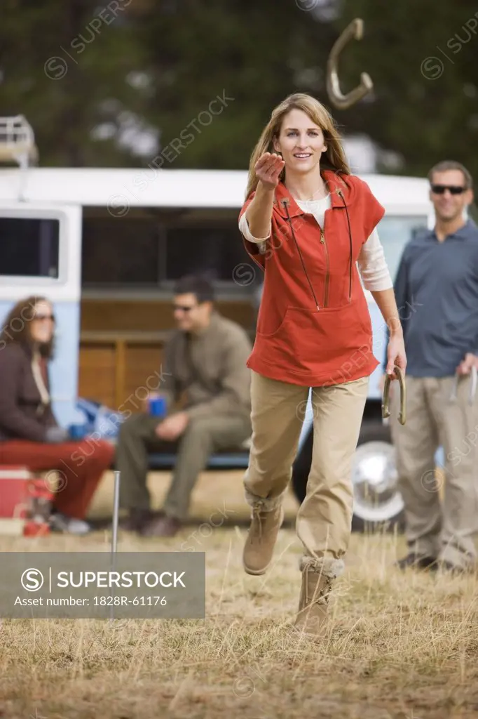 Woman Tossing Horseshoes While on a Camping Trip, Bend, Oregon, USA   