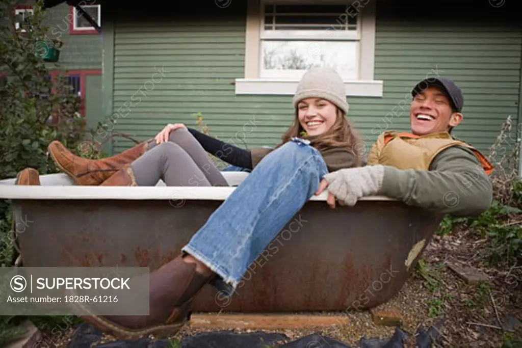 Laughing Couple Sitting in an Old Bathtub in Hillsboro, Oregon, USA   