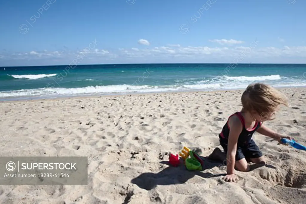 Girl Digging on Beach, Fort Lauderdale, Florida, USA   