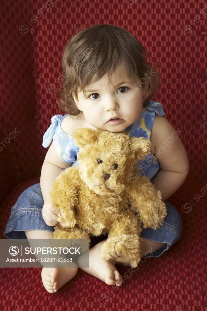 Little Girl Sitting on Chair with Teddy Bear   