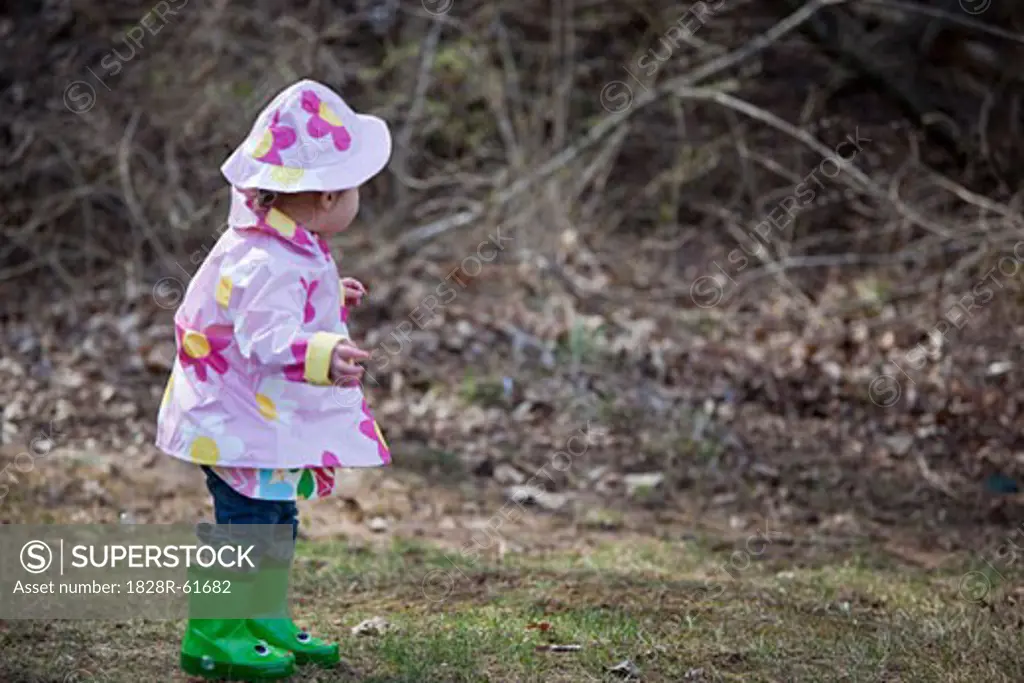 Little Girl in the Park Wearing Raincoat, Hat, and Boots, Bethesda, Maryland, USA   
